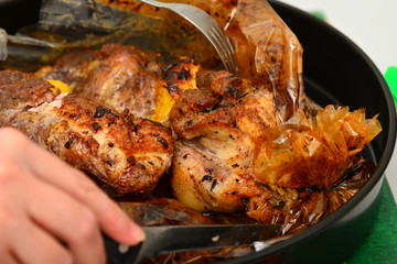 Roasted meat baked in the oven, knife and fork cutting roast.