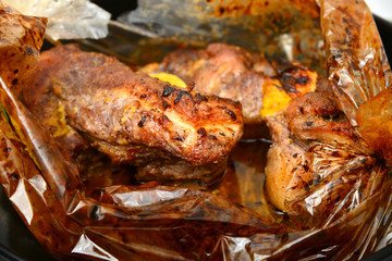 Fried juicy barbecue meat baked in the oven on a baking sheet.