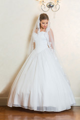 Fototapeta na wymiar Beautiful young bride in white wedding dress