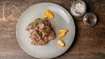 Food banner. Roasted turkey meat with citrus and rosemary on a large gray plate. Top view