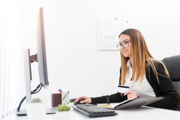 Young woman using her credit card for purchasing on line.