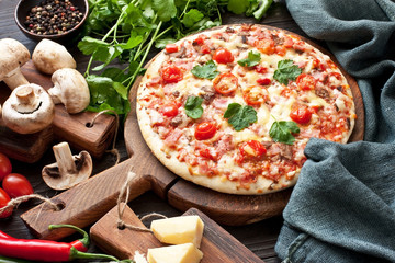 Traditional  italian pizza on wooden table with ingredients