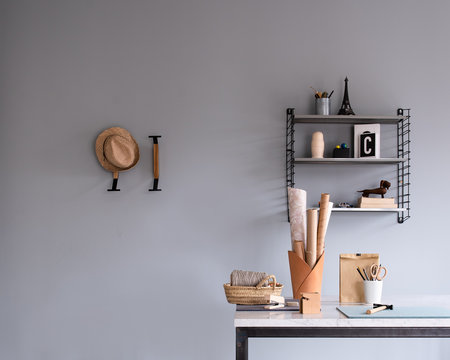 Details eines Zimmers: Arbeitsplatz, Schreibtisch, Wandregal, Wandhaken, Papierrollen