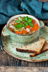 Bowl of delicious vegetables soup on wooden table