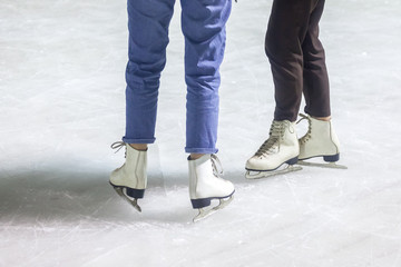 feet on the skates of a person rolling on the ice rink