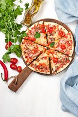 Delicious pizza served on light wooden table