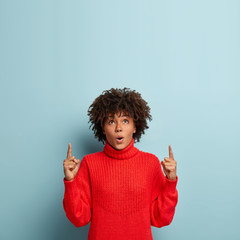 People, reaction, promotion concept. Studio shot of surprised beautiful female shop assistant...