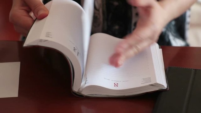 woman showing a blank agenda. She doesn't have any plans: calendar is clear 