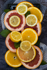 Fototapeta na wymiar Colorful assortment of citrus fruits. Dark background