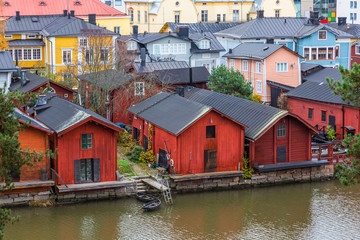 Fototapeta na wymiar Porvoo town, Finland. Old red wooden houses on the river coast on a cloudy day