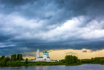 Fototapeta na wymiar Beautiful church on the river bank after rain