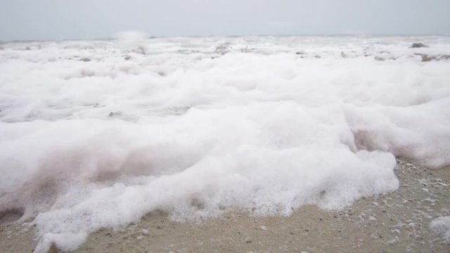 Foam blown by strong winds roaring at the shore of what is left of the dying Aral Sea, Uzbekistan