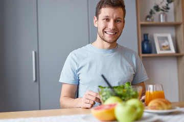 Smiling guy with delicious and healthy breakfast  