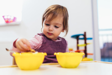 Cute child playing on table indoor, selective focus