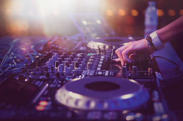 Female dj plays live music set on stage in night club