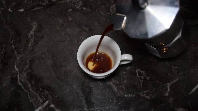 Caff&egrave; moka, la tazzina viene riempita di caff&egrave; appena preparato con una caffettiera italiana tipo Moka