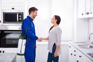Smiling Woman Showing Thumbs Up Sign With Pest Control Worker