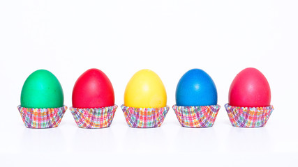 Easter. Multi-colored eggs. Five colorful eggs in paper baskets. White background.