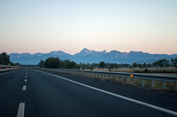 Sunrise over the mountains above the highway (Italy)