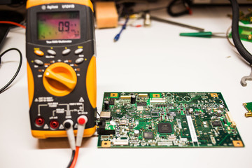 yellow modern multimeter with electrical board at the background