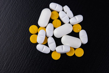 Medical tablets on a wooden table. Various medical medicines. Dark background.