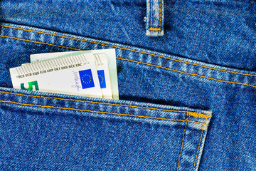 Several bills of five euros in the back pocket of jeans. Concept of absentminded person, potential victim of theft.