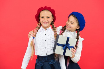 Gift for her. Birthday surprise. Little girl giving present to her friend. Happy children with small gift box wrapped with ribbon bow. Small kids enjoying holiday celebration. Happy birthday