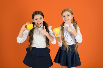 They are tasty. Fruits are high in vitamin. Cute schoolgirls like apples. School children with healthy apple snack. Little girls taking school snack break. Small girls enjoying natural vitamin food