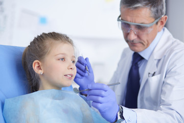 Fototapeta premium Little girl sitting in the dentists office