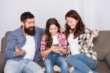 Child share news with mother and father. Little girl child use mobile phone. Happy family at home. Buy online. Child with childhood happiness. bearded man and woman with child. Family bonds