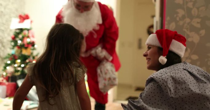 Santa arriving home, little girl feeling bashful shy seeing santa visiting family