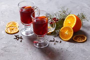 mulled red wine with spices and orange on dark background. warming drink
