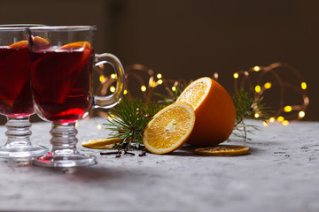 mulled red wine with spices and orange on dark background. warming drink