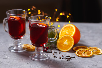 mulled red wine with spices and orange on dark background. warming drink