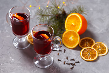 mulled red wine with spices and orange on dark background. warming drink