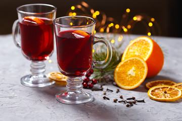 mulled red wine with spices and orange on dark background. warming drink