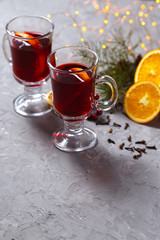 mulled red wine with spices and orange on dark background. warming drink