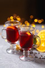 mulled red wine with spices and orange on dark background. warming drink