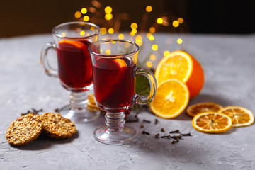mulled red wine with spices and orange on dark background. warming drink