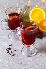 mulled red wine with spices and orange on dark background. warming drink