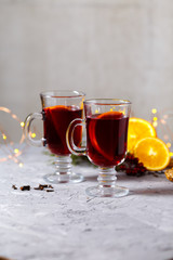 mulled red wine with spices and orange on dark background. warming drink