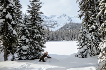 A young woman having fun around Island Lake in Fernie, British Columbia, Canada.  The majestic winter background is an absolutely beautiful place to go hiking or snowshoeing with fresh fallen snow.