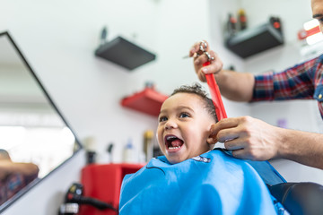 Cute Boy Getting a Hair Cut in a Barber Shop. Beauty Concept.