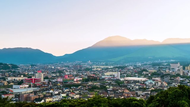 Beppu, Japan. A sunset time-lapse in a resort town of Beppu, Japan, with a view of mountains embracing the city and layers of sun. Zoom in