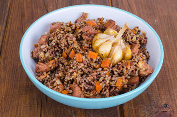 Red rice, risotto, pilaf with chicken and vegetables, garlic