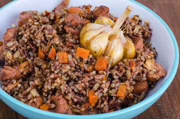 Red rice, risotto, pilaf with chicken and vegetables, garlic