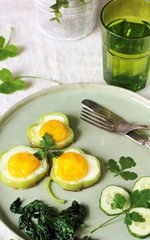 green breakfast on St. Patrick's Day. eggs in the form of clover. Fried Eggs Shamrock  in Green Pepper rings with Braised Spinach. parsley leaves like clover leaves.