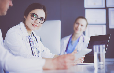 Serious medical team using a laptop in a bright office