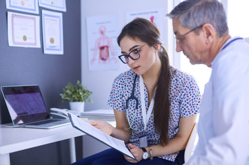 Two doctors speaking in a bright office
