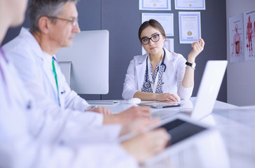 Serious medical team using a laptop in a bright office